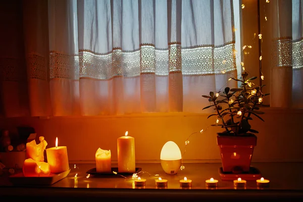 Przytulna dekoracja parapecie z wieloma świecami i jasnymi garlandami — Zdjęcie stockowe
