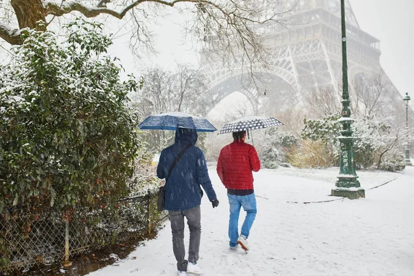 パリの雪の日に傘を持って歩く人々 — ストック写真