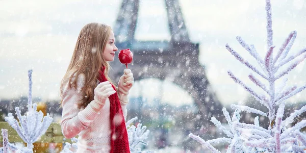 Mädchen mit Karamell-Apfel auf einem Pariser Weihnachtsmarkt — Stockfoto