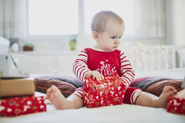 Menina pequena feliz abrindo presentes de Natal em seu primeiro Natal — Fotografia de Stock