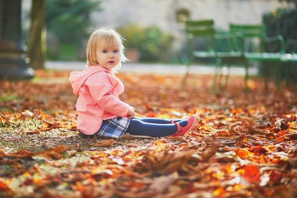 Menina adorável criança sentada no chão no jardim Tuileries em Paris, França — Fotografia de Stock