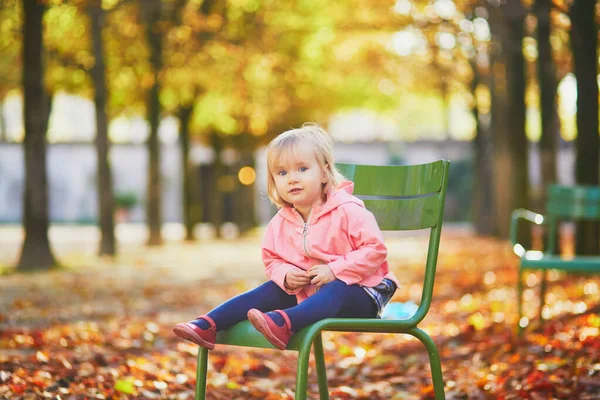 Adorable toddler girl sitting on traditional green chair in Tuileries garden in Paris — ストック写真