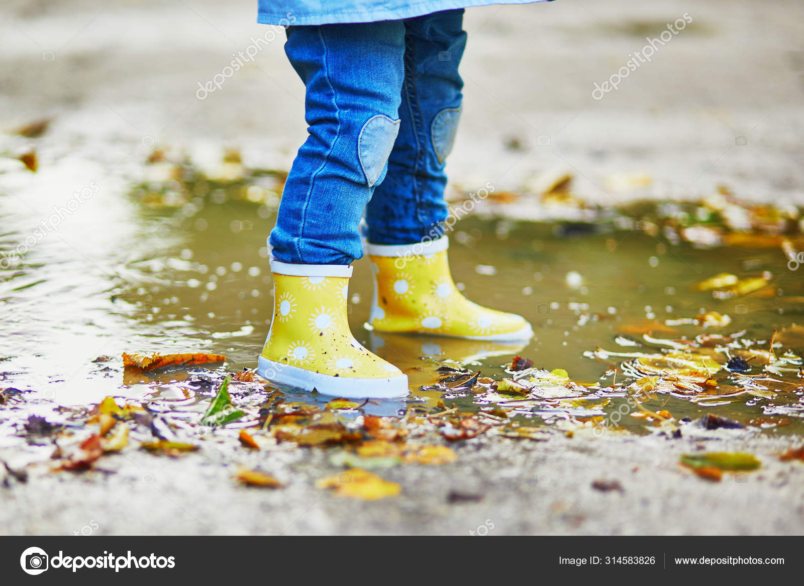 Criança usando botas de chuva amarelas e pulando na poça — Foto © encrier  #314583826, image size:1600x1167