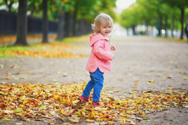 Paris, Fransa 'da parkta koşan sevimli, neşeli küçük kız.