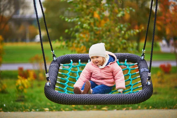 Urocza Dziewczynka Placu Zabaw Maluch Bawiący Się Huśtawce Jesienny Dzień — Zdjęcie stockowe