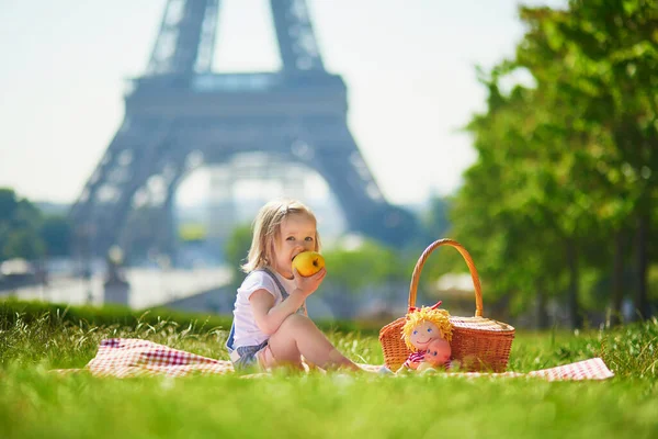 フランスのパリのエッフェル塔の近くでピクニックをしている陽気な幼児の女の子 夏の日に公園でおもちゃで遊ぶ幸せな子供 屋外で健康的な軽食を楽しむ子供 — ストック写真