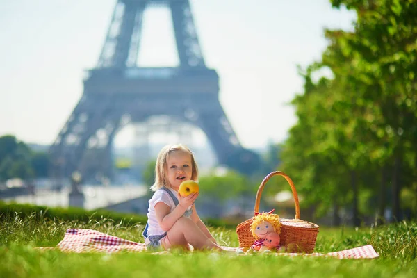 フランスのパリのエッフェル塔の近くでピクニックをしている陽気な幼児の女の子 夏の日に公園でおもちゃで遊ぶ幸せな子供 屋外で健康的な軽食を楽しむ子供 — ストック写真