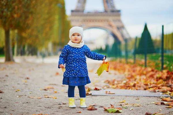 Приваблива Дівчинка Синьому Плащі Збирає Жовті Листки Біля Ейфелевої Вежі — стокове фото