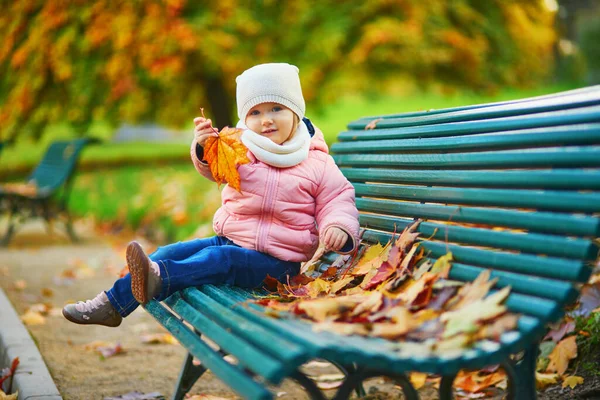 Menina Adorável Criança Sentada Banco Brincando Com Folhas Caídas Parque — Fotografia de Stock