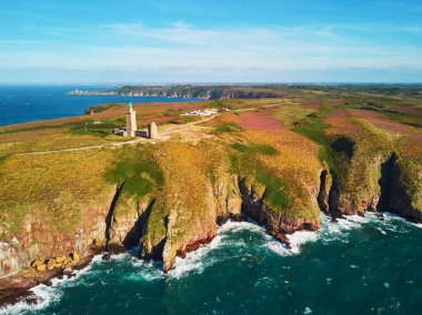 Cape Frehel 'in deniz feneriyle manzarası, Fransa' nın Brittany kentindeki en popüler turizm merkezlerinden biri. Ünlü GR34 izleme yolu boyunca yaygın olarak bilinen turist çekimini gösteren hava aracı görüntüsü