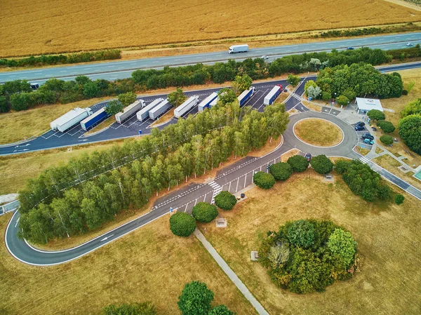 Aerial drone view of cargo truck parking neat and six-lane motorway in Brittany, France