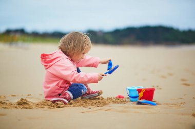 Brittany, Fransa 'nın Atlantik kıyısındaki kumsalda oynayan sevimli küçük kız. Küçük çocuk deniz ya da okyanus kenarında tatilin tadını çıkarıyor. Çocuklarla seyahat etmek.