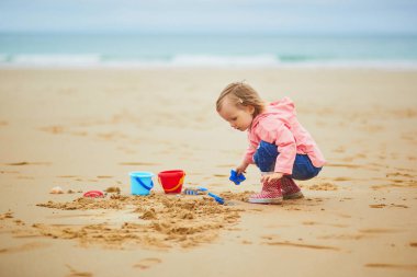 Brittany, Fransa 'nın Atlantik kıyısındaki kumsalda oynayan sevimli küçük kız. Küçük çocuk deniz ya da okyanus kenarında tatilin tadını çıkarıyor. Çocuklarla seyahat etmek.