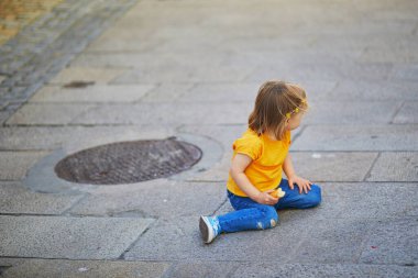 Mutsuz ve duygusal küçük kız dışarıda yerde oturuyor. Sokakta yaramazlık yapan bir çocuk. Korkunç ikililer ve çocuk nöbetleri konsepti