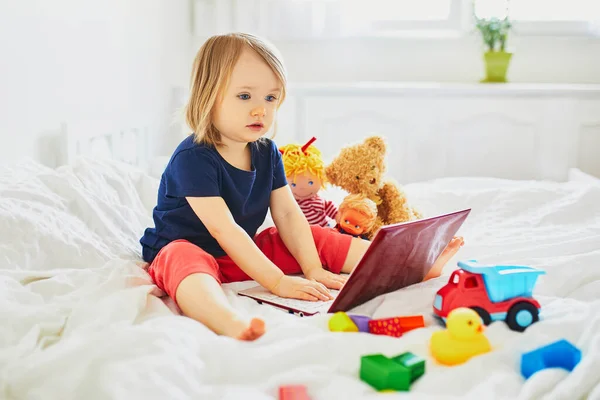 Дівчина Ноутбуком Іграшками Ліжку Малюк Використовує Гаджет Спілкування Друзями Або — стокове фото