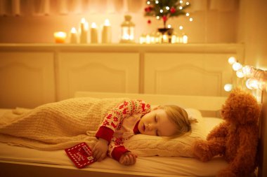 Oyuncak ayıyla uyuyan sevimli küçük kız ve elinde Noel ağacının altında Noel Baba 'ya yazdığı mektup. Yeni yıl arifesinde çocuk yatakta rüya görür.