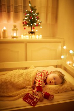 Oyuncak ayıyla uyuyan sevimli küçük kız ve elinde Noel ağacının altında Noel Baba 'ya yazdığı mektup. Yeni yıl arifesinde çocuk yatakta rüya görür.