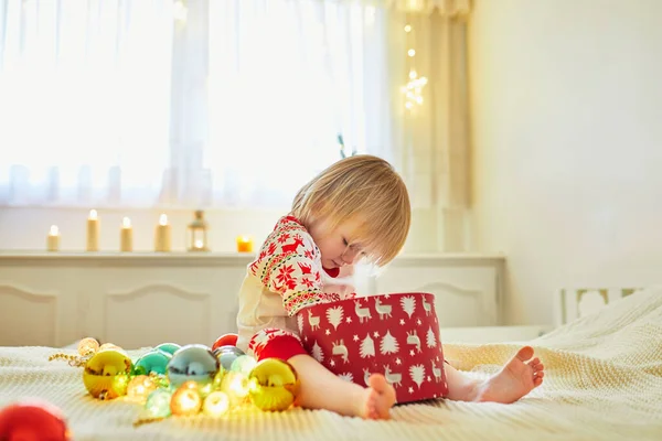 快乐的小女孩穿着睡衣 躺在床上玩圣诞装饰品 与孩子们一起庆祝节日 — 图库照片