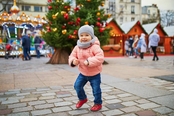 パリのクリスマスマーケットで愛らしい幼児の女の子 季節の休暇中に屋外で楽しい時間を過ごす幸せな子供 クリスマスと新年を子供たちと祝う — ストック写真