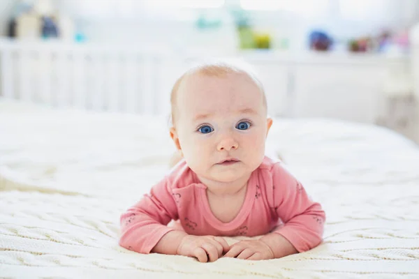 可爱的女婴躺在床上肚子上 健康的幼儿快乐地练习爬行 在阳光灿烂的托儿所里做肚子饿的婴儿 — 图库照片