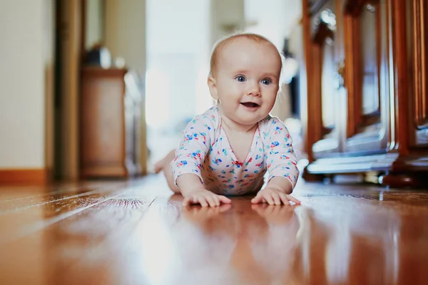 小女孩在学习爬行 快乐健康的小孩躺在地板上 幼儿在家里 — 图库照片
