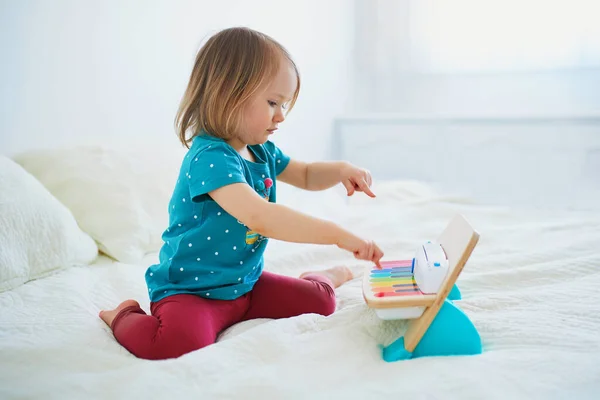 可爱的小女孩在家里 幼儿园或幼儿园里弹着玩具钢琴 为儿童提供创意游戏 教育和远程学习 待在家里娱乐 — 图库照片