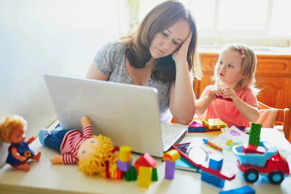 疲れ果て ストレスの多い母親は幼児と一緒に家から働いています コロナウイルス発生時の隔離および閉鎖保育所 仕事中の子供は騒音や不穏な女性を作ります 子供とのフリーランスの仕事 — ストック写真