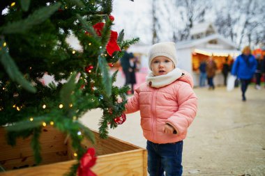 Paris 'te Noel pazarında küçük sevimli bir kız. Mutlu çocuk mevsimsel tatillerde dışarıda eğleniyor. Yılbaşını ve Noel 'i çocuklarla kutluyoruz.