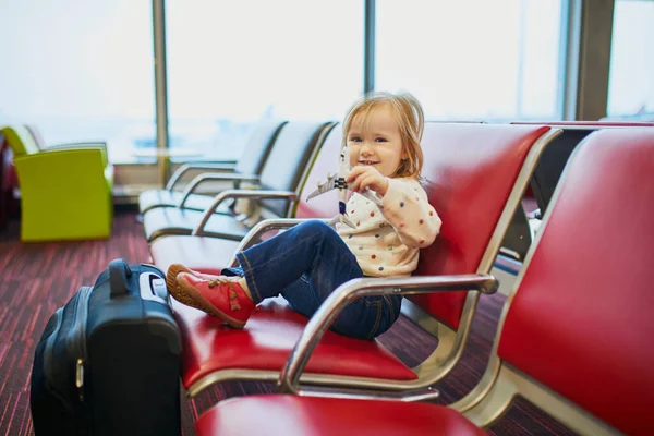 飛行機で旅行する愛らしい小さな幼児の女の子 子供たちはゲートに座ってフライトを待っています 子供と一緒に海外旅行 同伴しない未成年の概念 — ストック写真