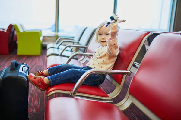 飛行機で旅行する愛らしい小さな幼児の女の子 子供たちはゲートに座ってフライトを待っています 子供と一緒に海外旅行 同伴しない未成年の概念 — ストック写真