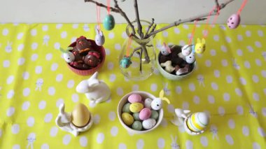 Renkli yumurtalar, tavuklar, lezzetli tatlılar ve çikolatalarla süslenmiş güzel Paskalya masası Paskalya kahvaltısı için servis edilir..