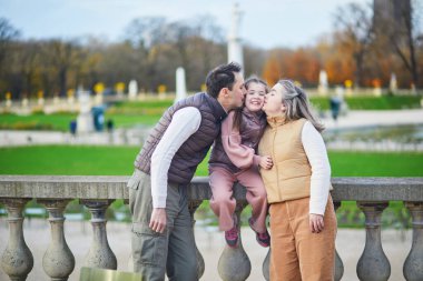 Üç kişilik mutlu bir aile, baba, anne ve kız Lüksemburg 'un Paris bahçesinde birlikte vakit geçiriyorlar.