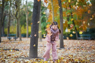 Paris, Fransa 'nın Lüksemburg bahçesinde bir sonbahar gününde eğlenen sevimli küçük kız.