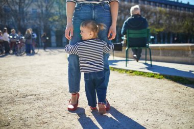Güzel genç anne ve tapılası küçük kızı Paris, Fransa 'da parkta birlikte yürüyorlar.