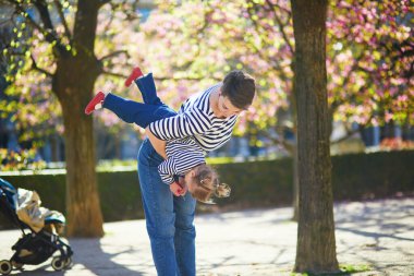 Güzel genç anne ve tapılası küçük kızı Paris, Fransa 'da parkta birlikte yürüyorlar.