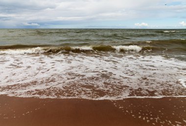 Bir bulutlu gökyüzü ve köpük su denize sıfır fırtınada.