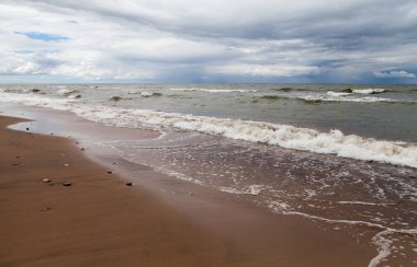 Bir bulutlu gökyüzü ve köpük su denize sıfır fırtınada.