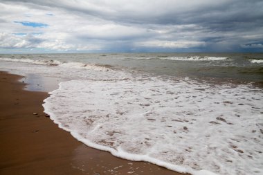 Bir bulutlu gökyüzü ve köpük su denize sıfır fırtınada.