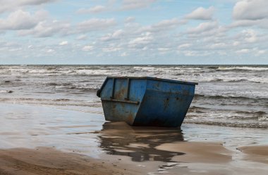 Deniz sahil şeridi üzerinde atıklar için büyük konteyner.