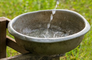 Kırsal kesimde su ile eski vintage alüminyum kase.