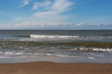 Mavi gökyüzü ile dalgalı Baltık Denizi.