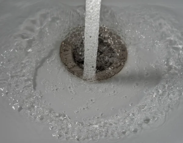 Vatten som rinner i diskhon. — Stockfoto