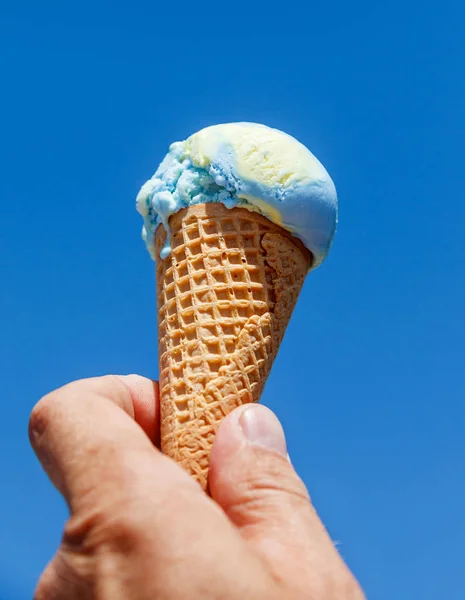 Ice cream cone in hand. Stock Picture