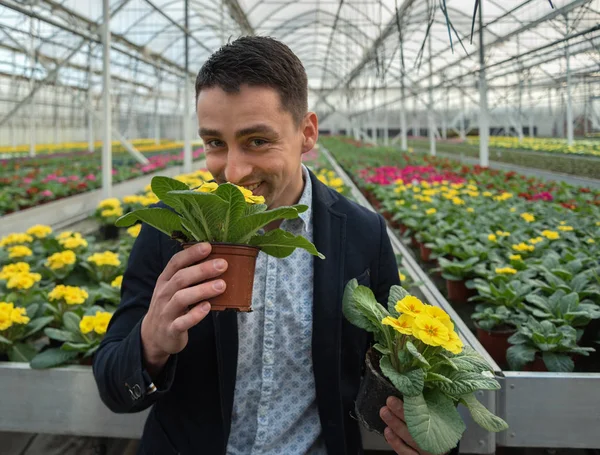 Smiling young man in greenhouse. — Stock Photo, Image