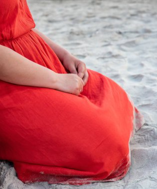 Kumlu sahilde hamile bir kadın.