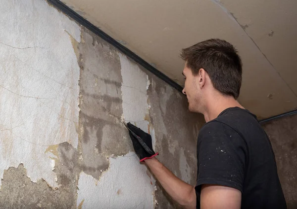 Επισκευαστής Καθαρίζει Τον Τοίχο Από Παλιά Ταπετσαρία — Φωτογραφία Αρχείου