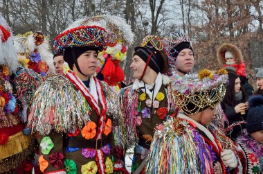 Chernivtsi, Bukovina, Ukrayna - 13 Ocak 2019: Genç erkek Noel ve Malanka halk mimarisinin Açık Hava Müzesi'nde etnik Festivali sırasında şarkı. Yapay çiçek, aynalar, kurdela ve boncuk ile dekore edilmiş karnaval kostüm giymiş adam