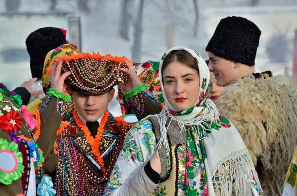 Chernivtsi, Ukrayna - 13 Ocak 2019: Genç Ukraynalı erkek ve kadın halk mimarisinin Açık Hava Müzesi'nde etnik Festivali sırasında Malanka şarkı gerçekleştirin. Geleneksel Ulusal elbise karnaval askeri giymiş erkekler, Bukovina, giymiş kadın