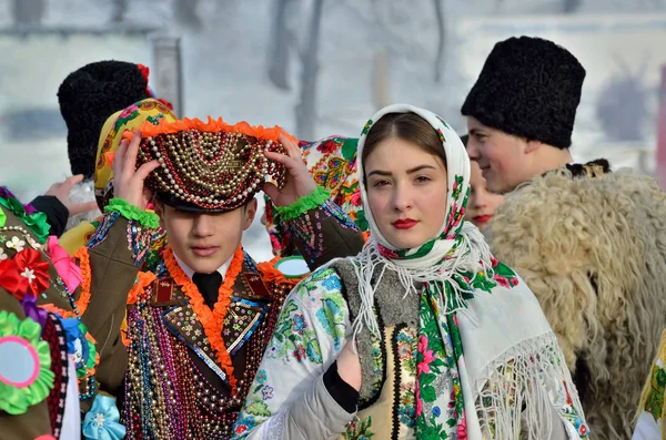 チェルニウツィー 西ウクライナ 2019 ウクライナの若い男と女は野外民俗建築博物館民族フェスティバルの期間中 Malanka 歌を実行します ブコヴィナのカーニバル軍部に身を包んだ男性伝統的な国民服を着た女性 ストックフォト