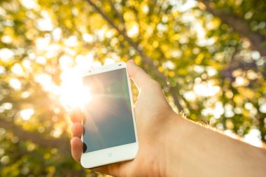 Açık havada cep telefonu kullanan bir adama yaklaş.